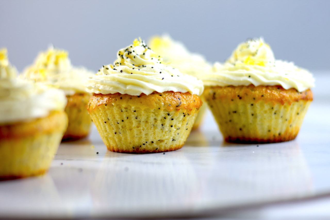 Keto and Lemon Poppyseed Muffins by Aussie Keto Queen. These deliciously sweet and tart muffins are the perfect treat to bake for a loved on, or yourself! Beautifully presented with piped frosting and extra lemon zest and poppyseeds, these are sure to please. 