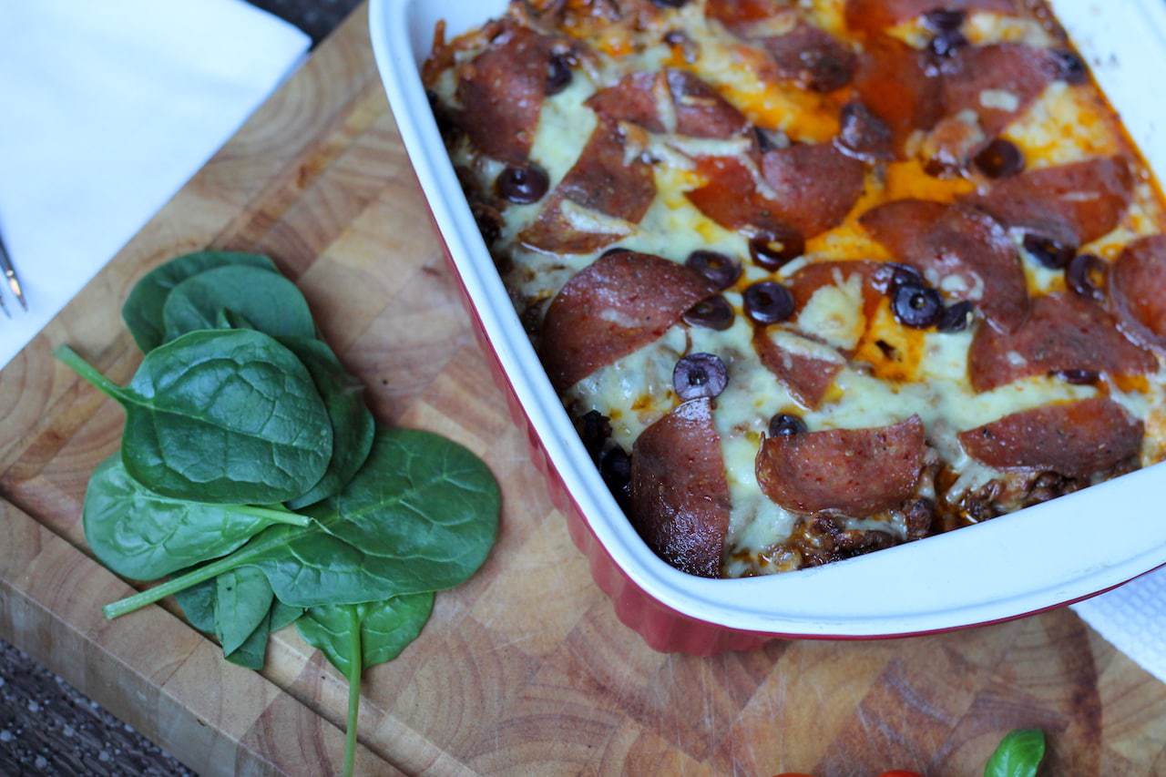 Keto Pizza Casserole with Cauliflower by Aussie Keto Queen.  This Keto Pizza Casserole could turn some cauli-haters into cauli-lovers in one mouthful. Using a base of cauliflower makes this dish a tasty alternative to the carb laden normal pizza, and with none of the fuss of making your own keto base. It is very calorie dense and rich, so serve it with a fresh green salad. All the flavour, none of the carbs! #keto #ketorecipes #ketogenicdiet