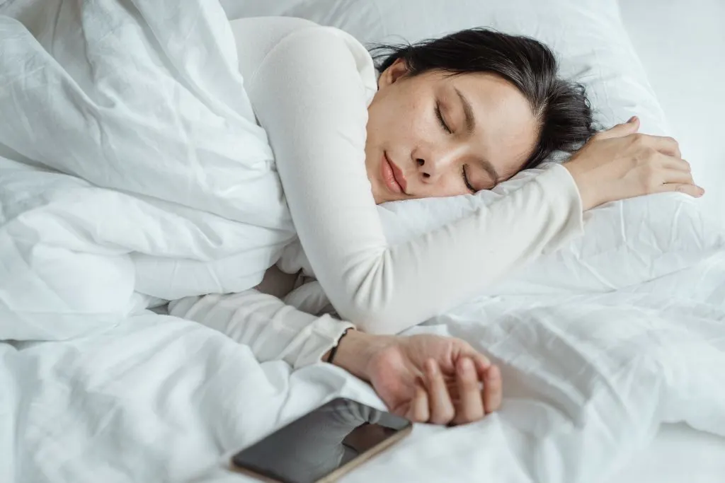 زنی که آرام می‌خوابد نشان داده می‌شود، با بهبود خواب یکی از مزایای کلیدی آبگوشت استخوان در رژیم کتو است. آب استخوان می تواند به شما کمک کند آرام شوید، سریعتر بخوابید و کیفیت کلی خواب خود را بهبود بخشد - برای کاهش وزن ضروری است.